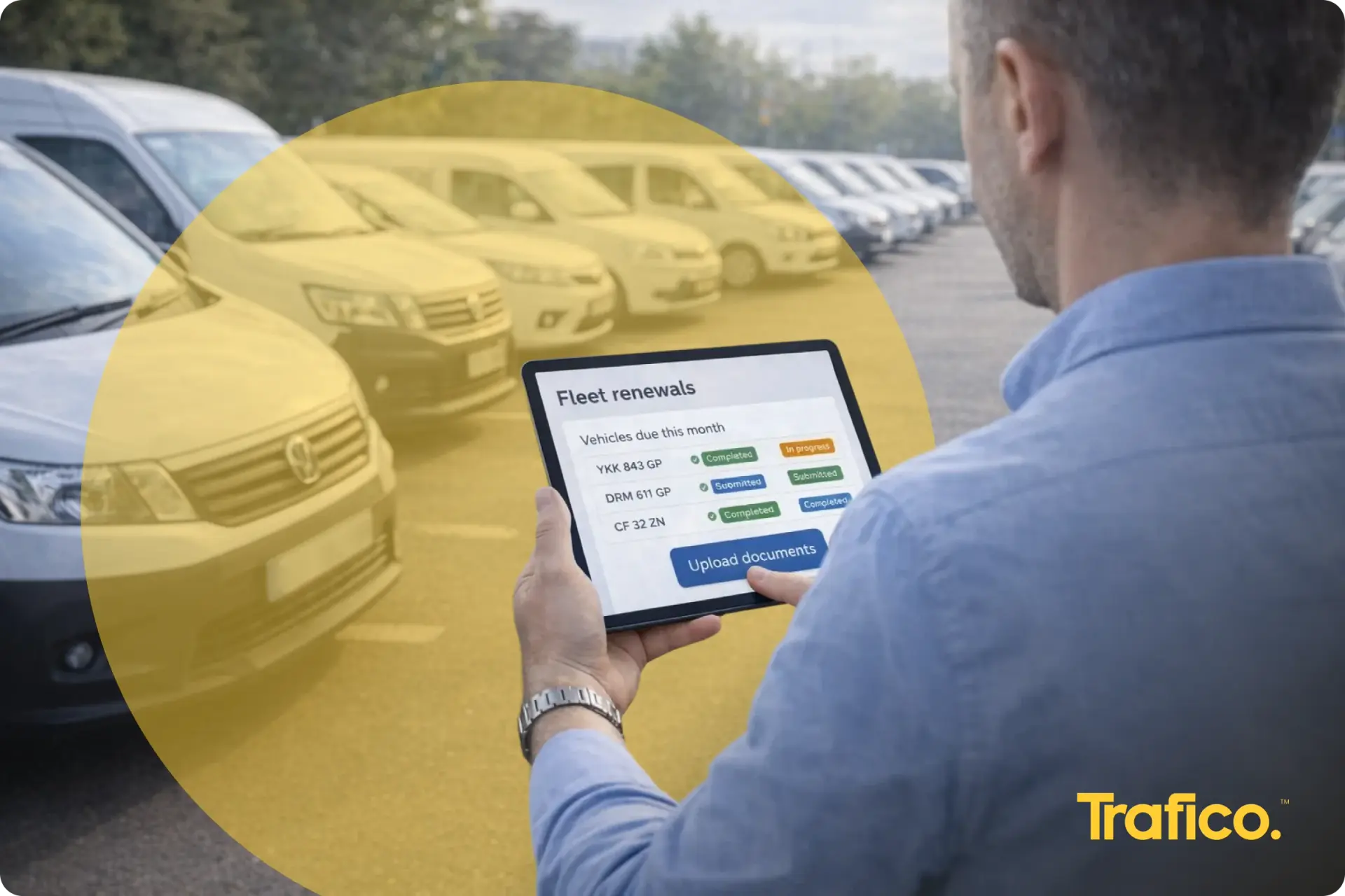 Fleet manager checking vehicle licence renewals on a tablet beside a row of company vans