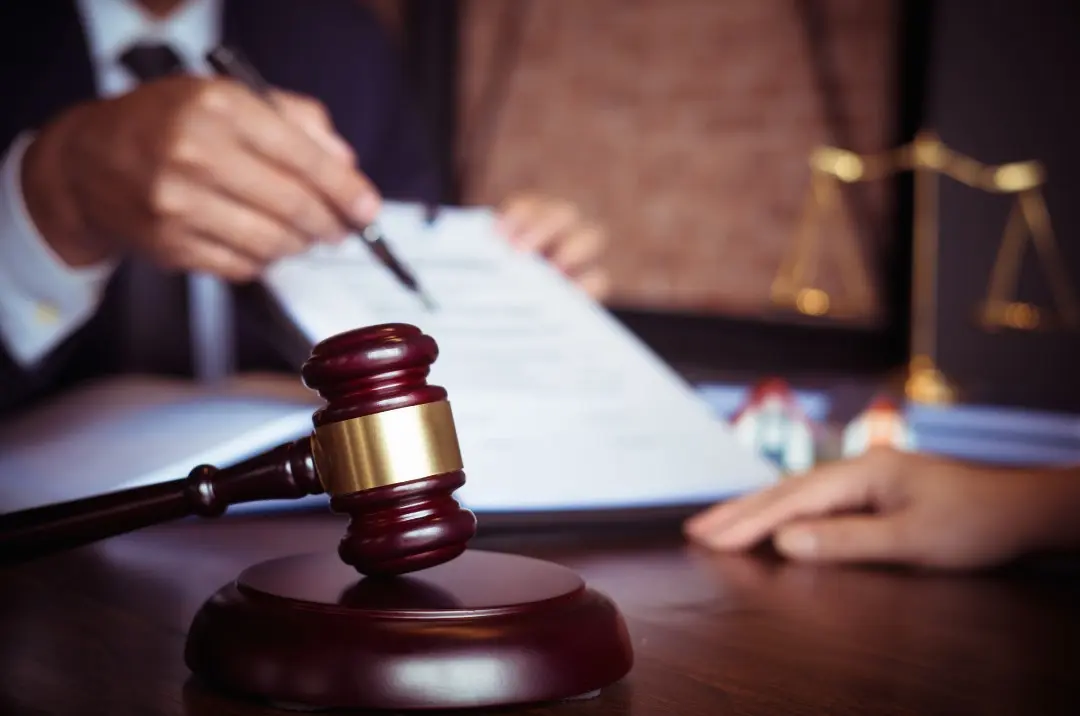 Judge's gavel beside a lawyer signing a document