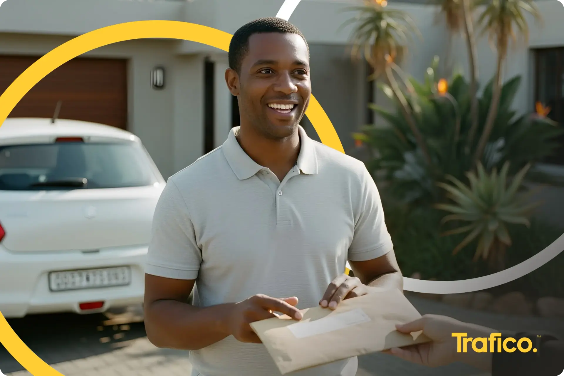 Smiling man holding his vehicle licence papers outside his home